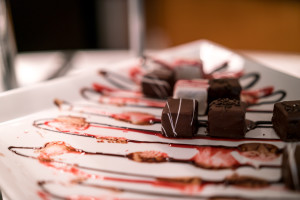 a plate of chocolates with red liquid
