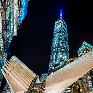 a tall buildings with lights at night with Taipei 101 in the background
