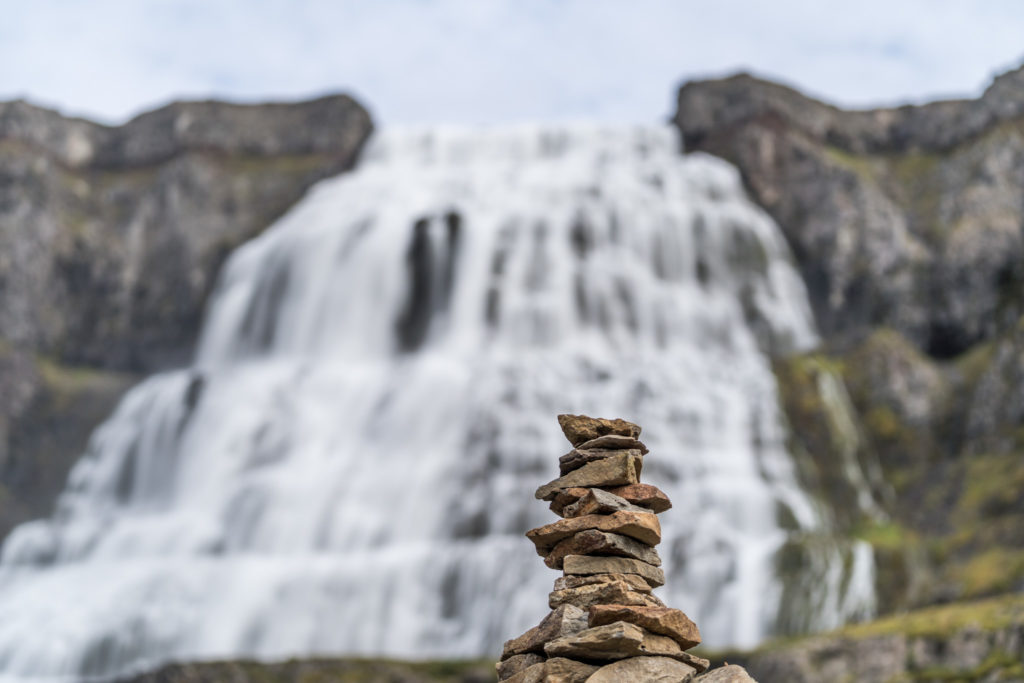 a stack of rocks in front of a waterfall