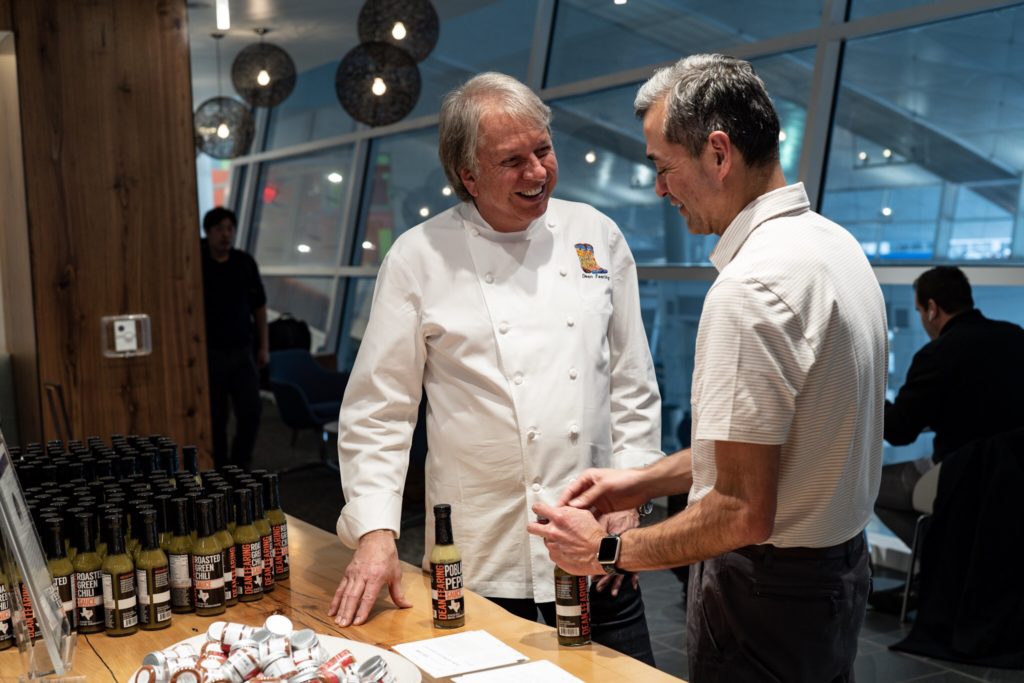 a man in a chef's coat talking to another man