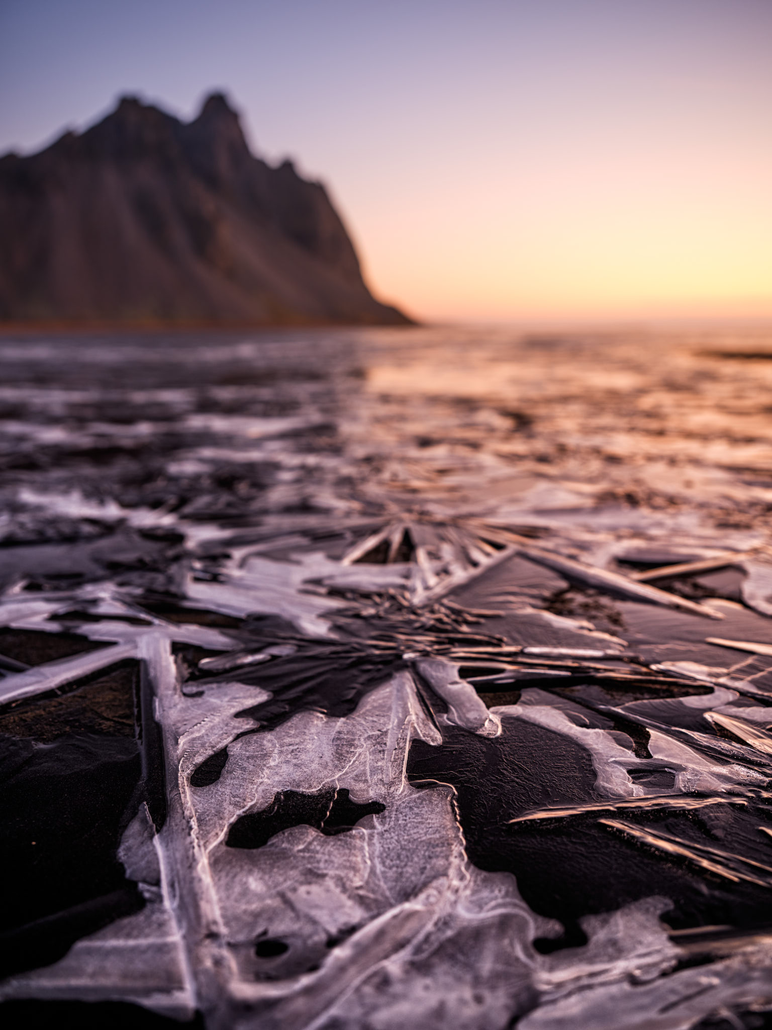 ice on the beach with a mountain in the background