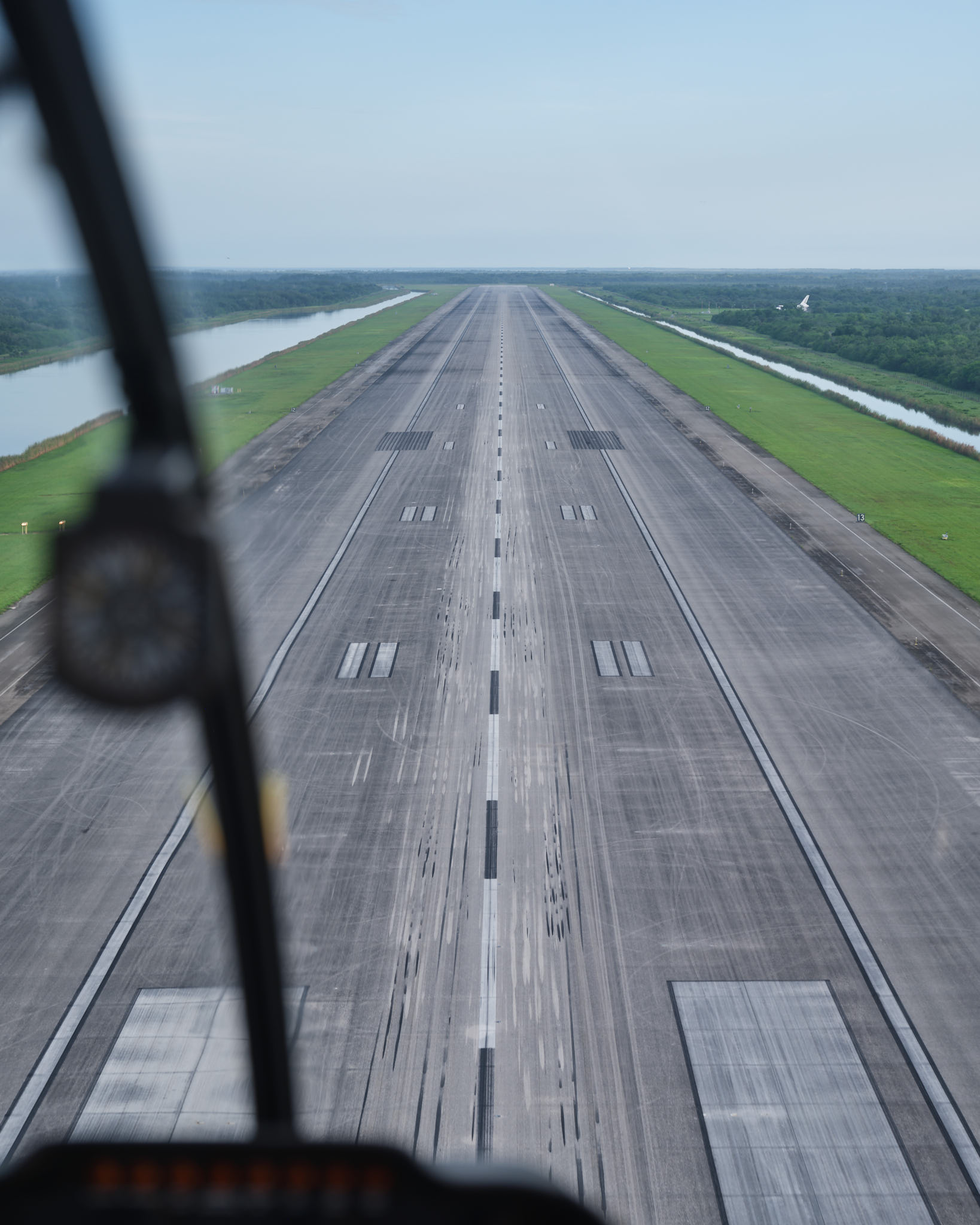 an airplane flying over a runway