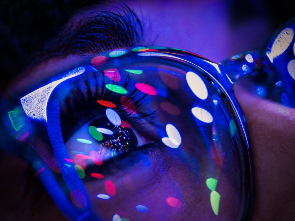 a person wearing glasses with colorful lights reflected on them