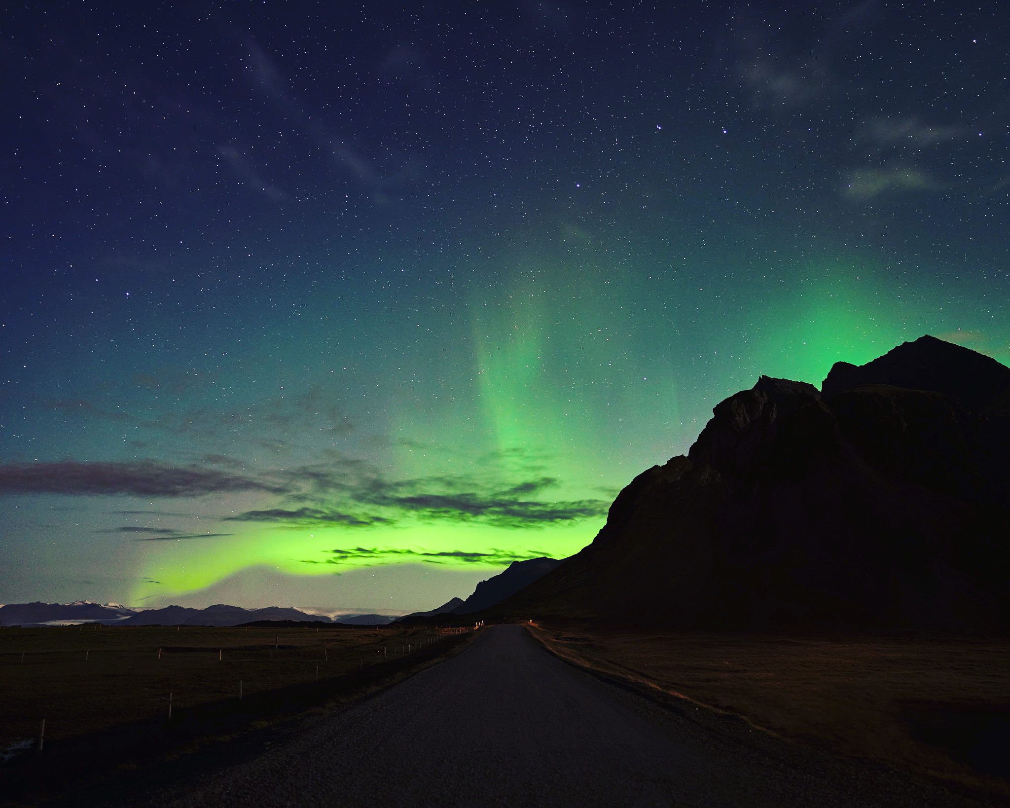 a road with green lights in the sky