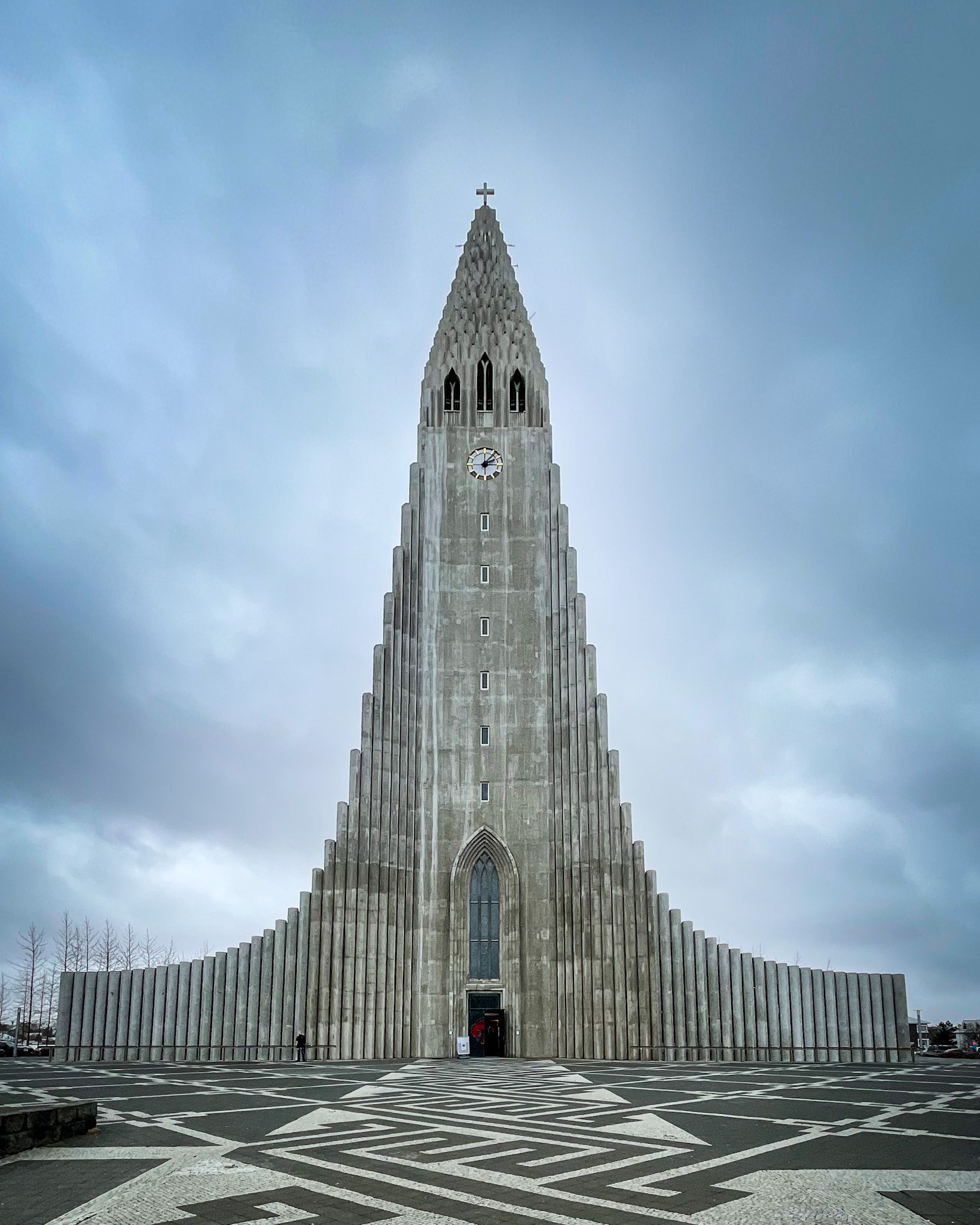 a large building with a clock on it with Hallgrímskirkja in the background