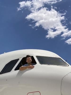 a man leaning out of a plane window