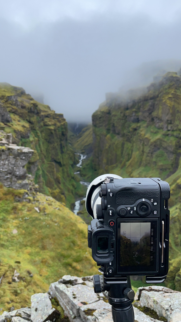 a camera with a camera lens and a valley in the background