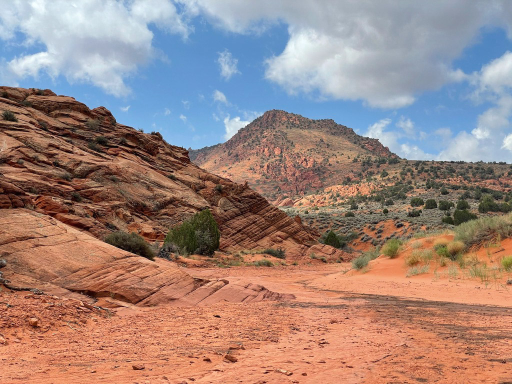 a red rock canyon with a blue sky and clouds