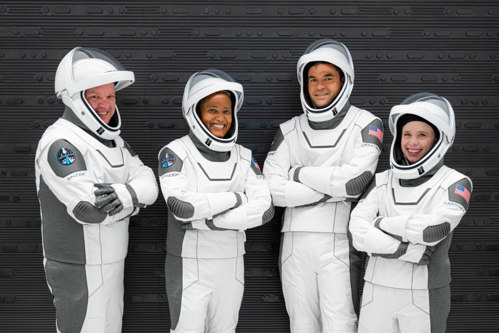a group of people in white space suits
