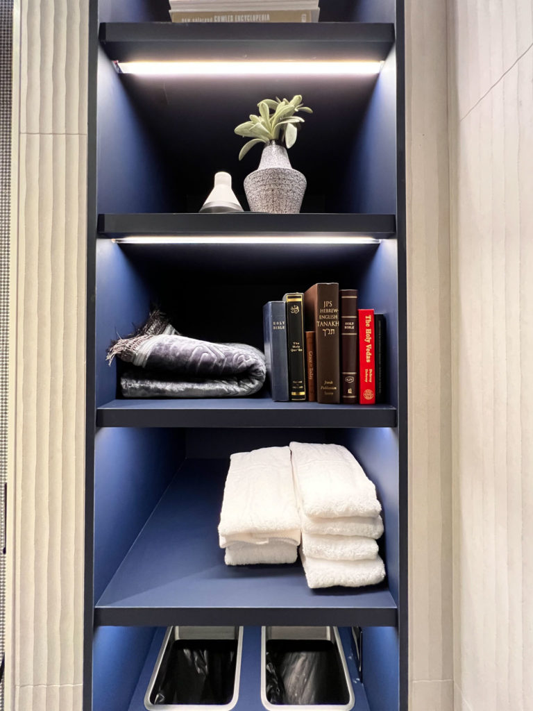 a shelf with books and towels