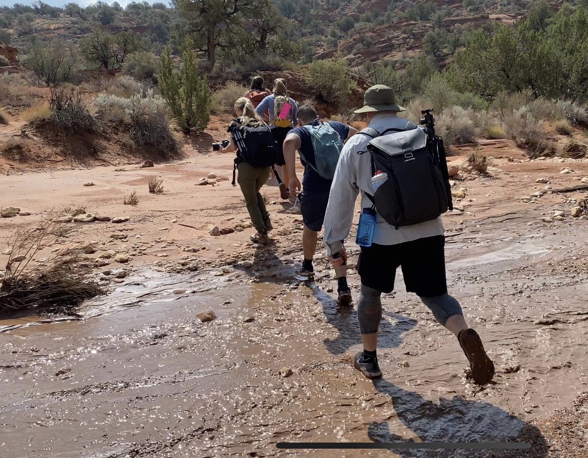 a group of people walking in a muddy area