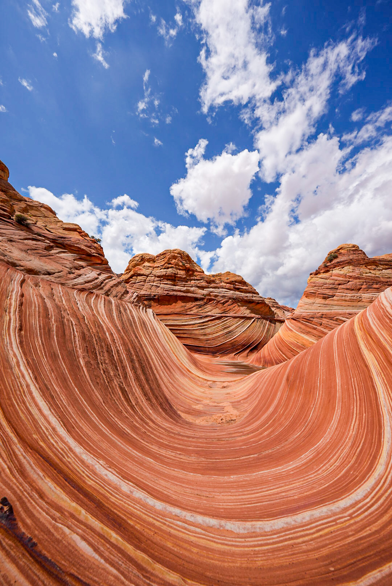 a red rock formation with blue sky and clouds