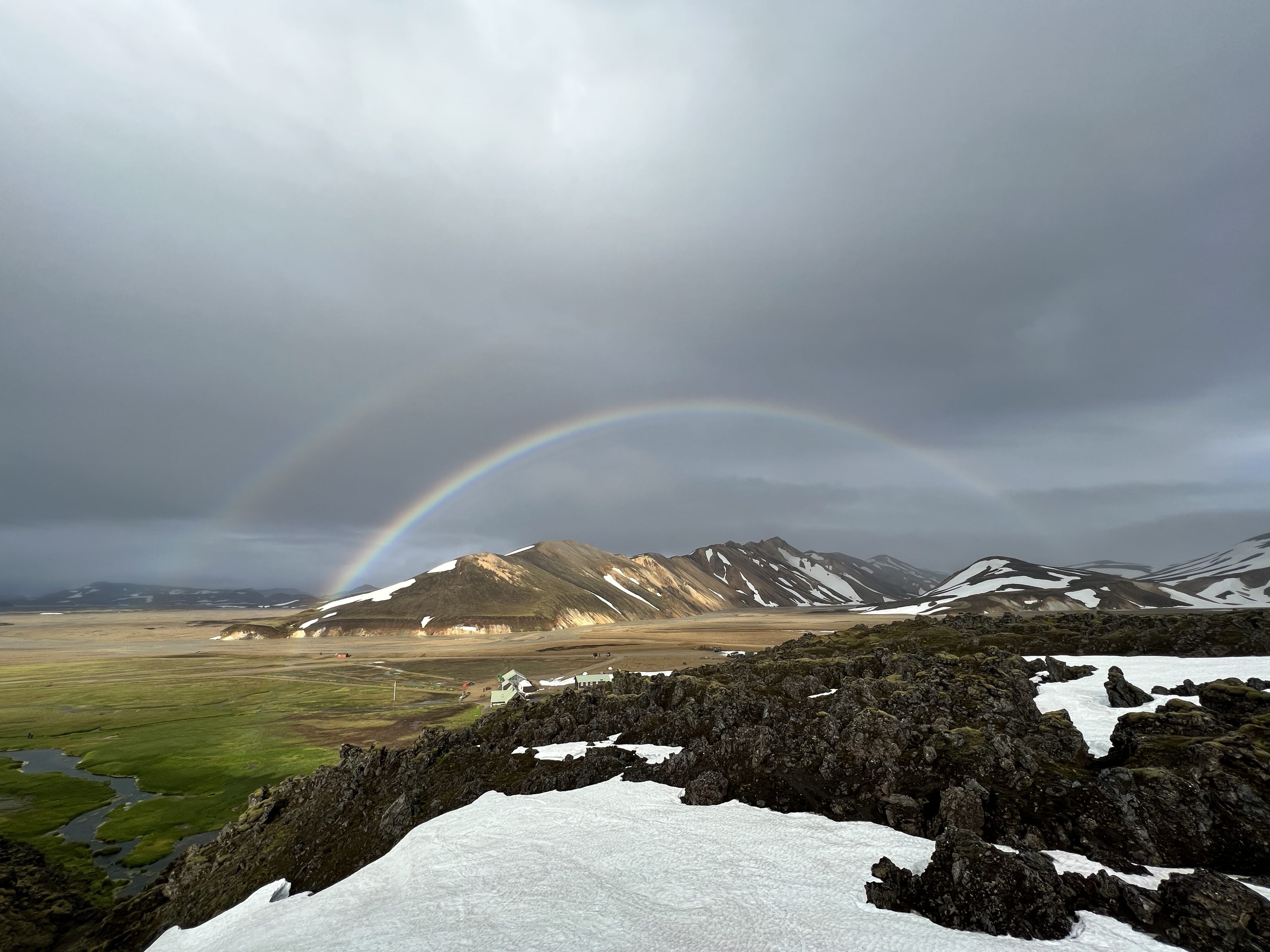 a rainbow over a snowy mountain