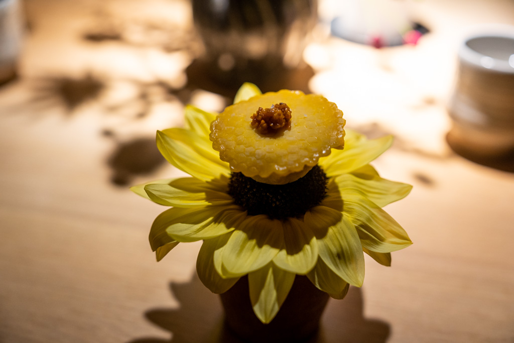 a yellow flower with a piece of food on top