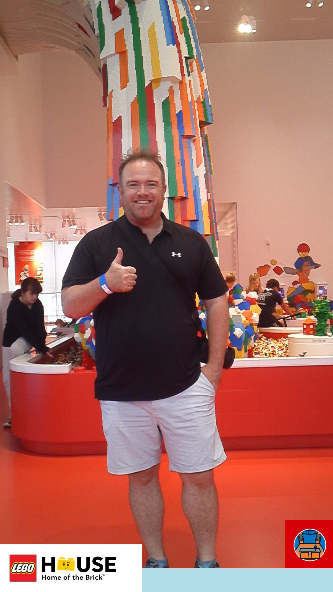 a man giving a thumbs up in a room with colorful legos