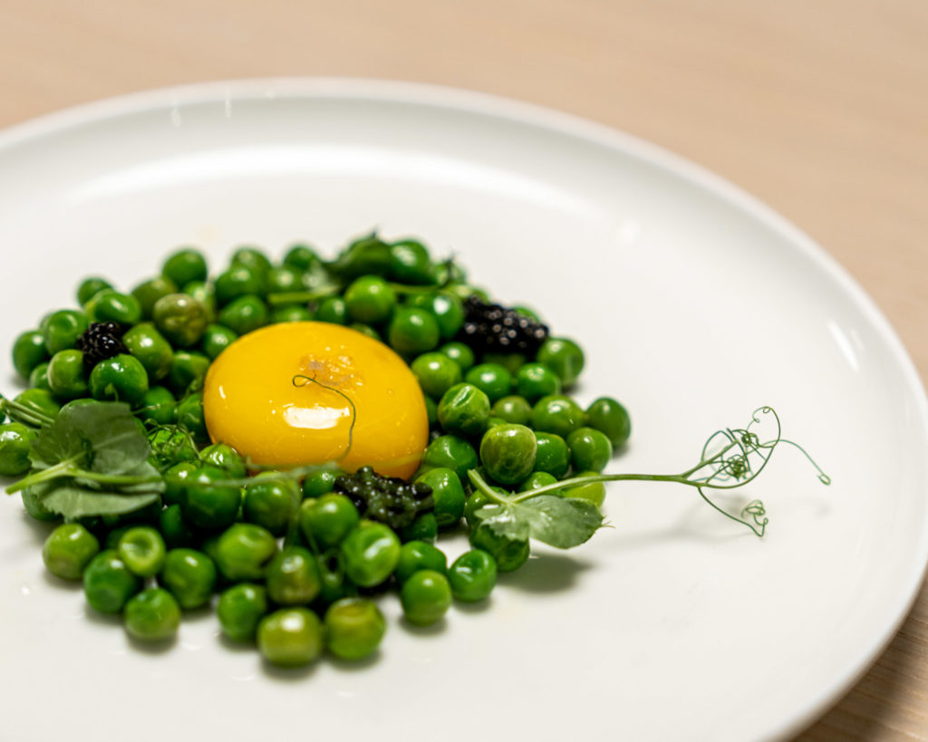 a plate of peas and a yolk on top