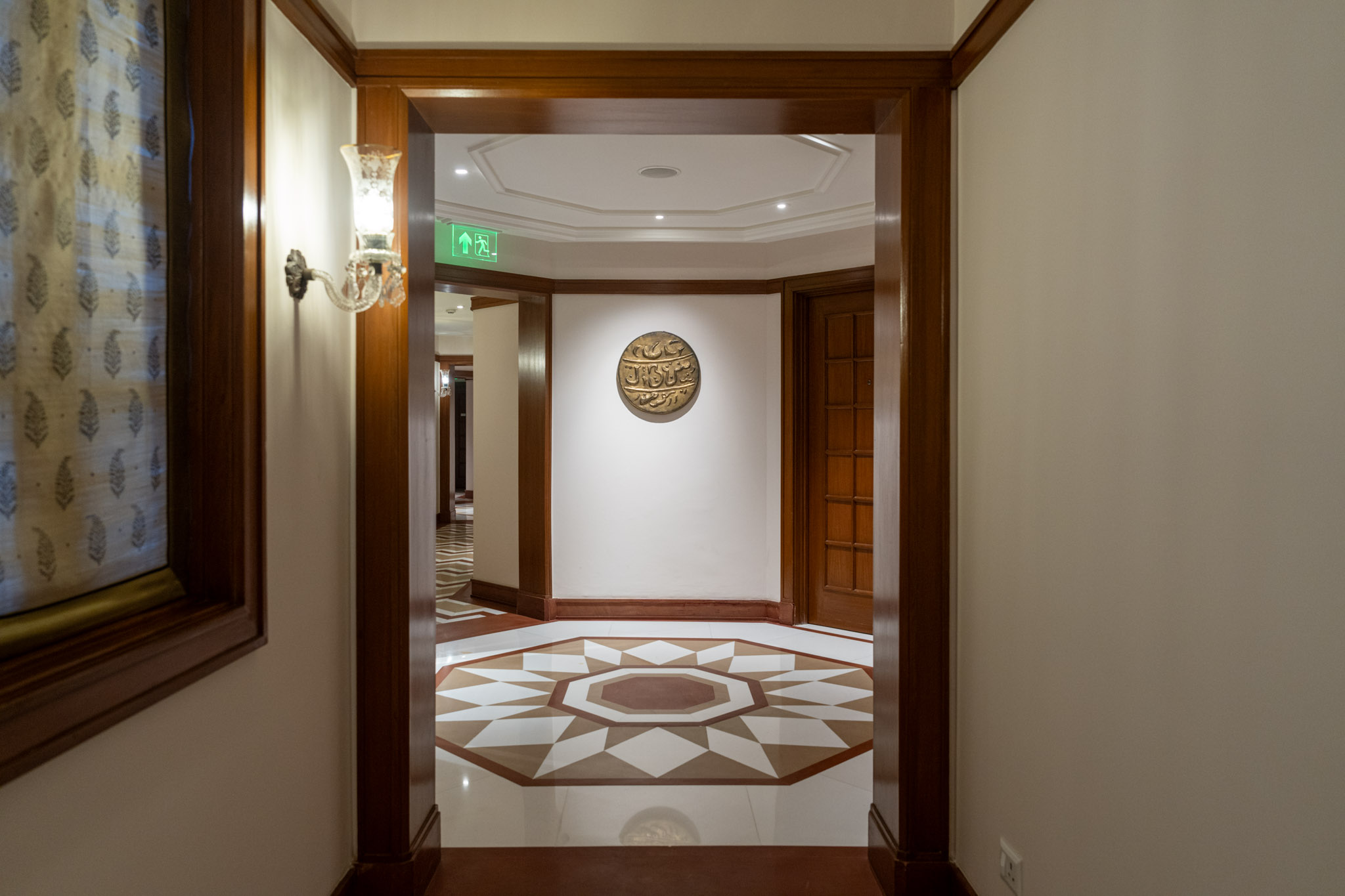 a hallway with a tile floor and a wall with a light fixture