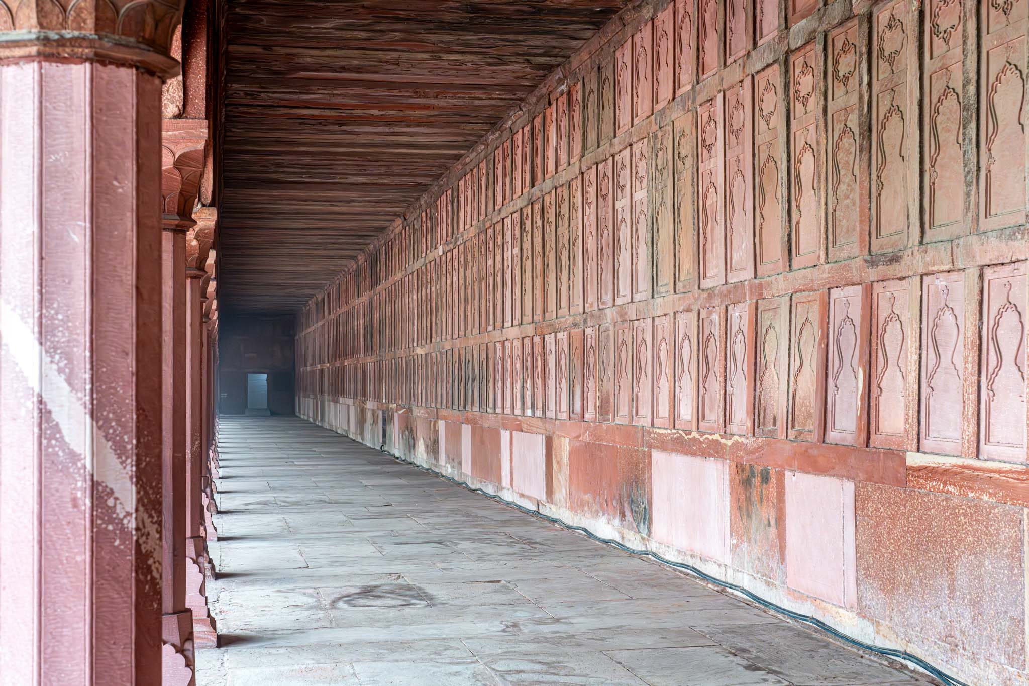 a long corridor with stone walls and pillars