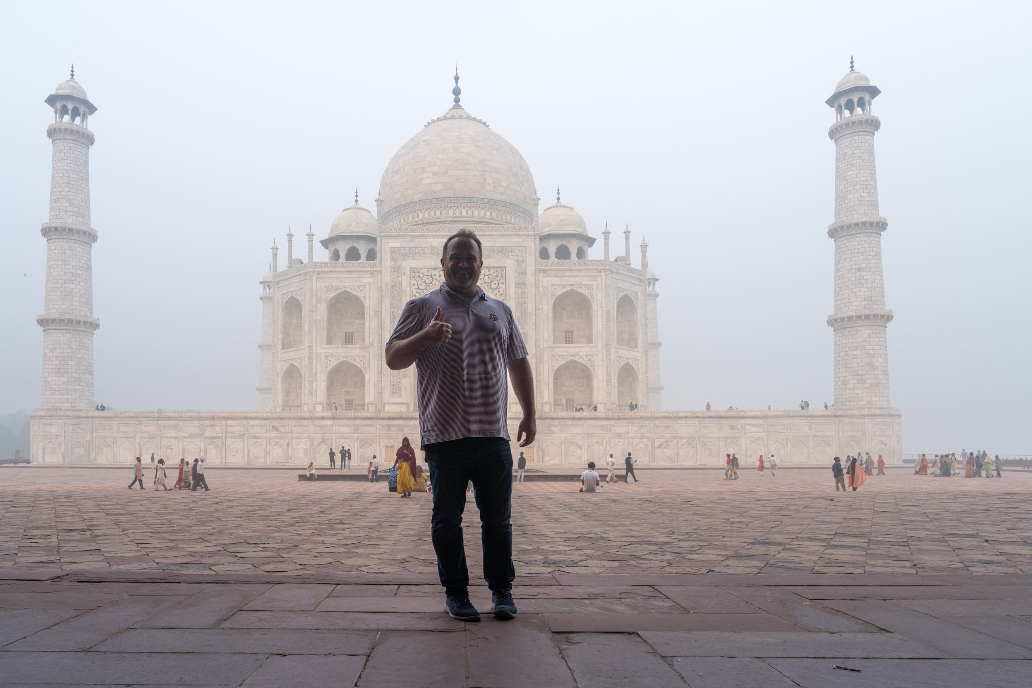 a man standing in front of a large building with Taj Mahal in the background