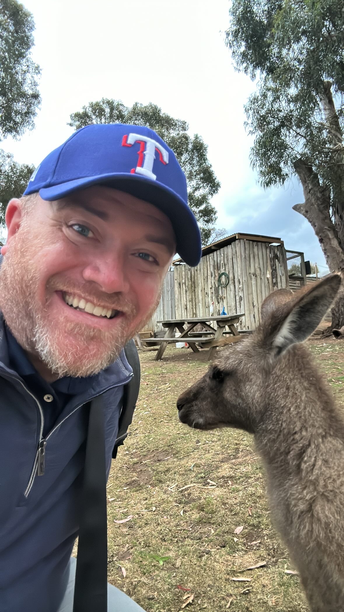 a man taking a selfie with a kangaroo