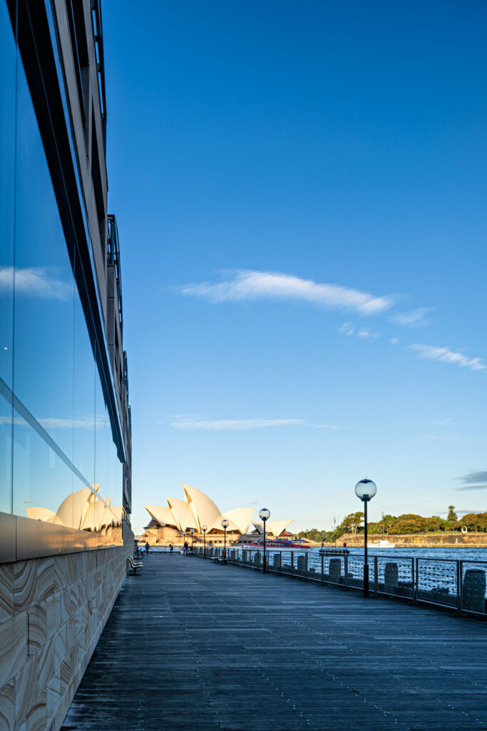 a walkway with a building and a body of water