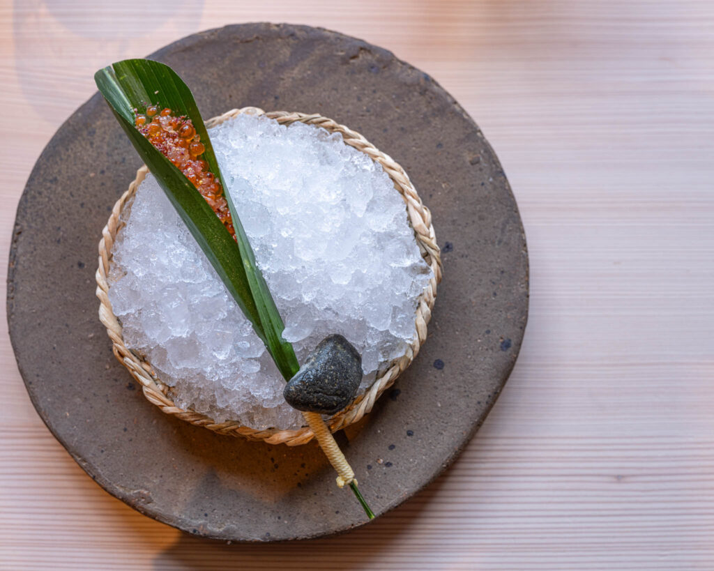 a bowl of ice and a leaf on a plate