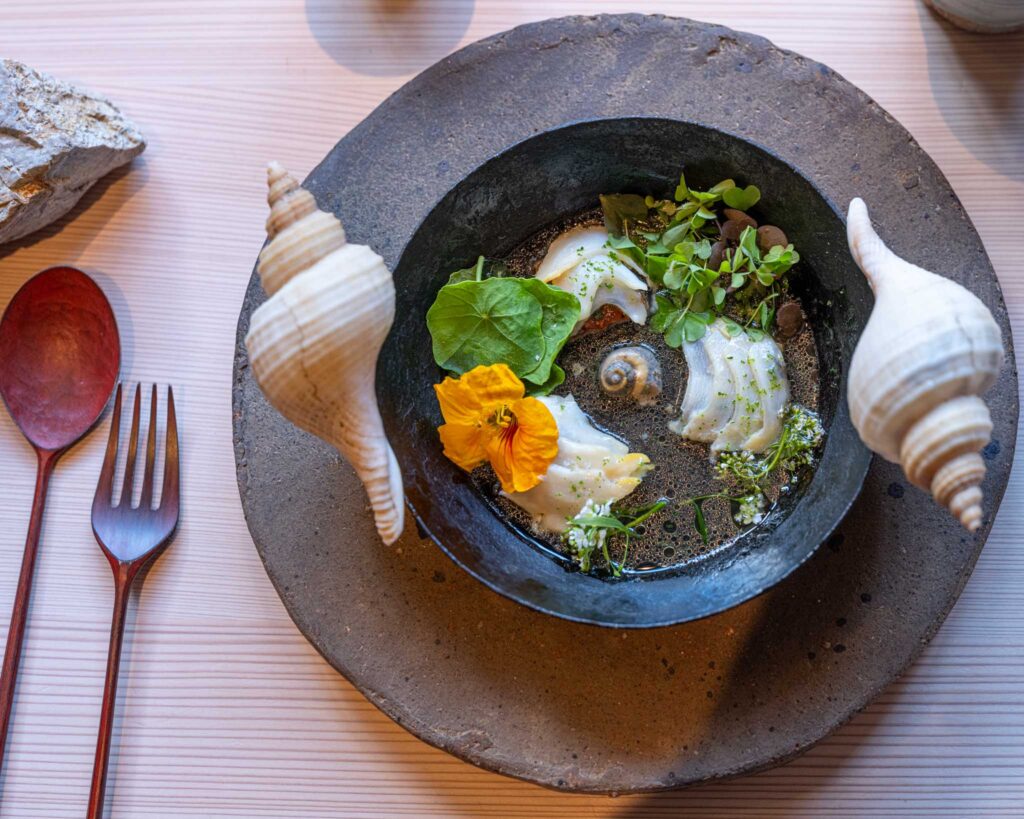 a bowl of food with shells and a fork