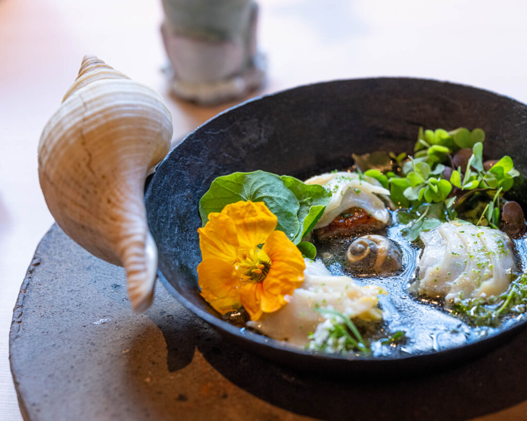 a pan of food with flowers and greens