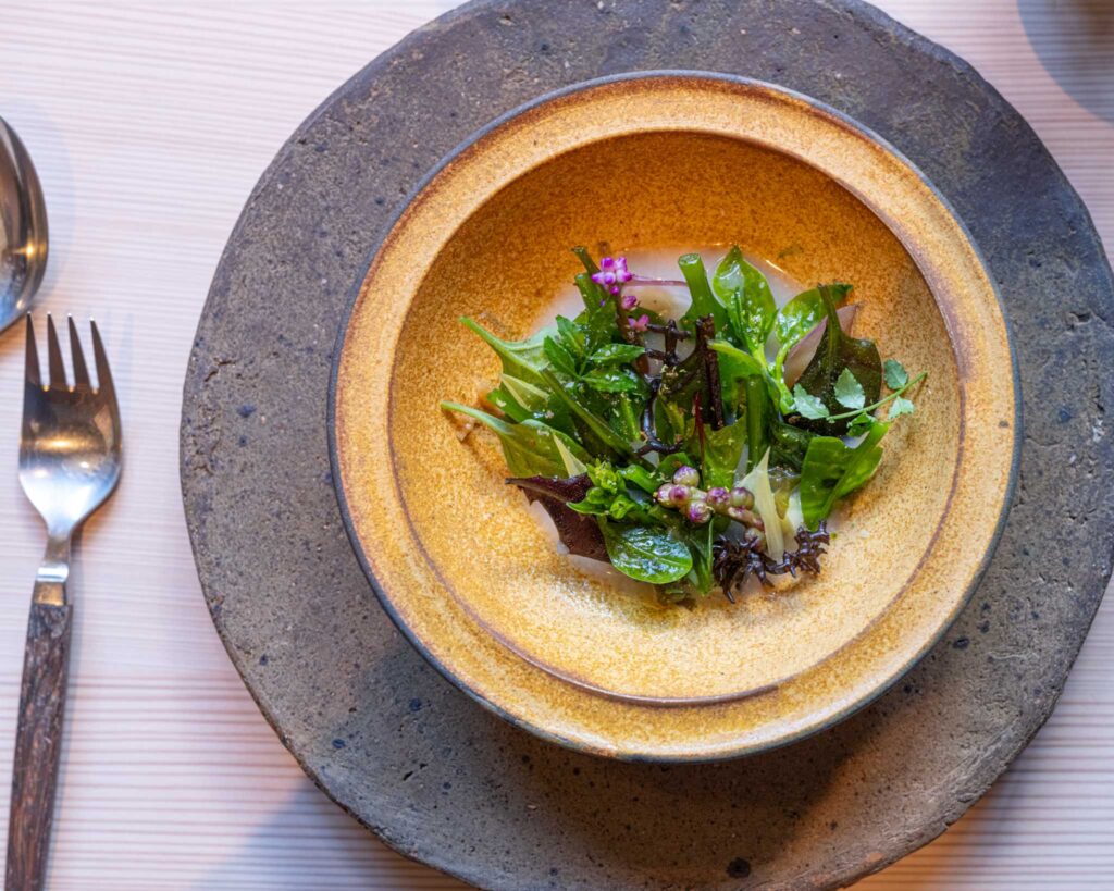 a bowl of green leaves on a plate