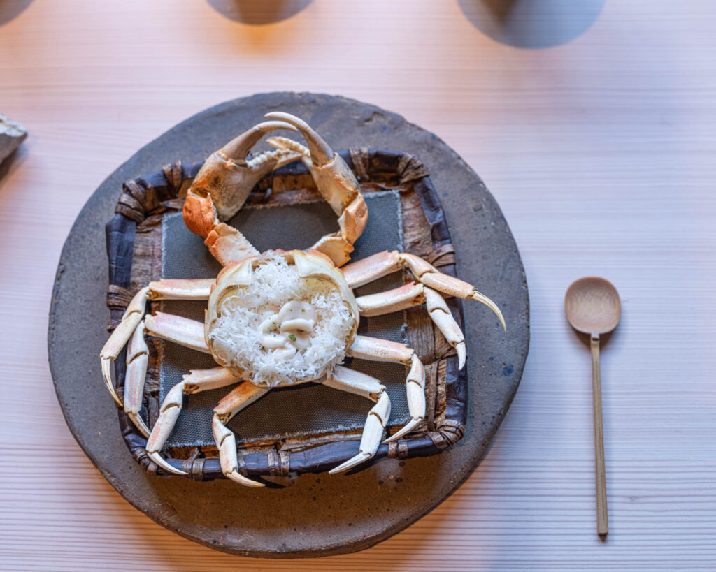 a crab on a plate with a spoon