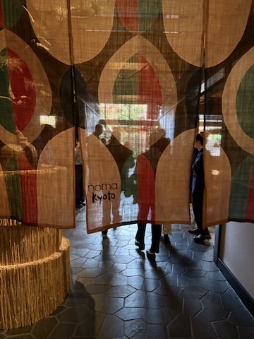 a group of people standing in a room with a curtain