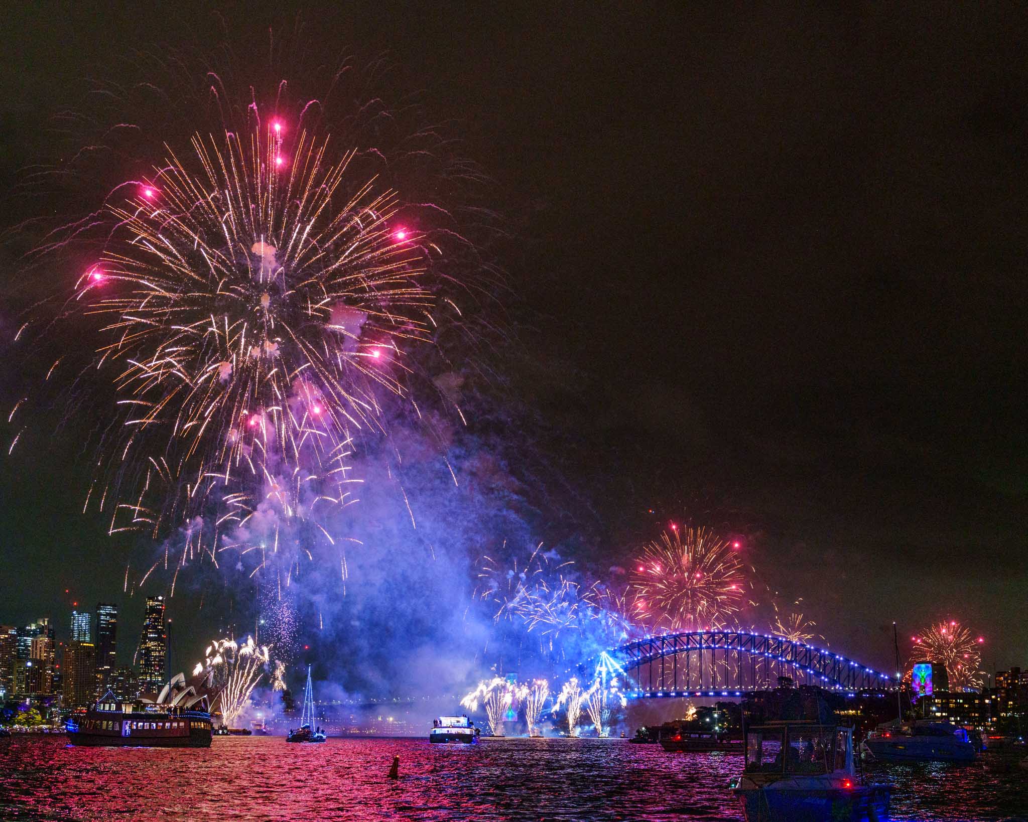 fireworks over a bridge at night