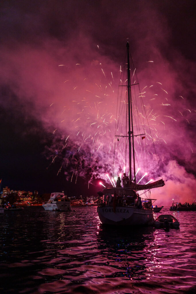 a boat with fireworks in the sky